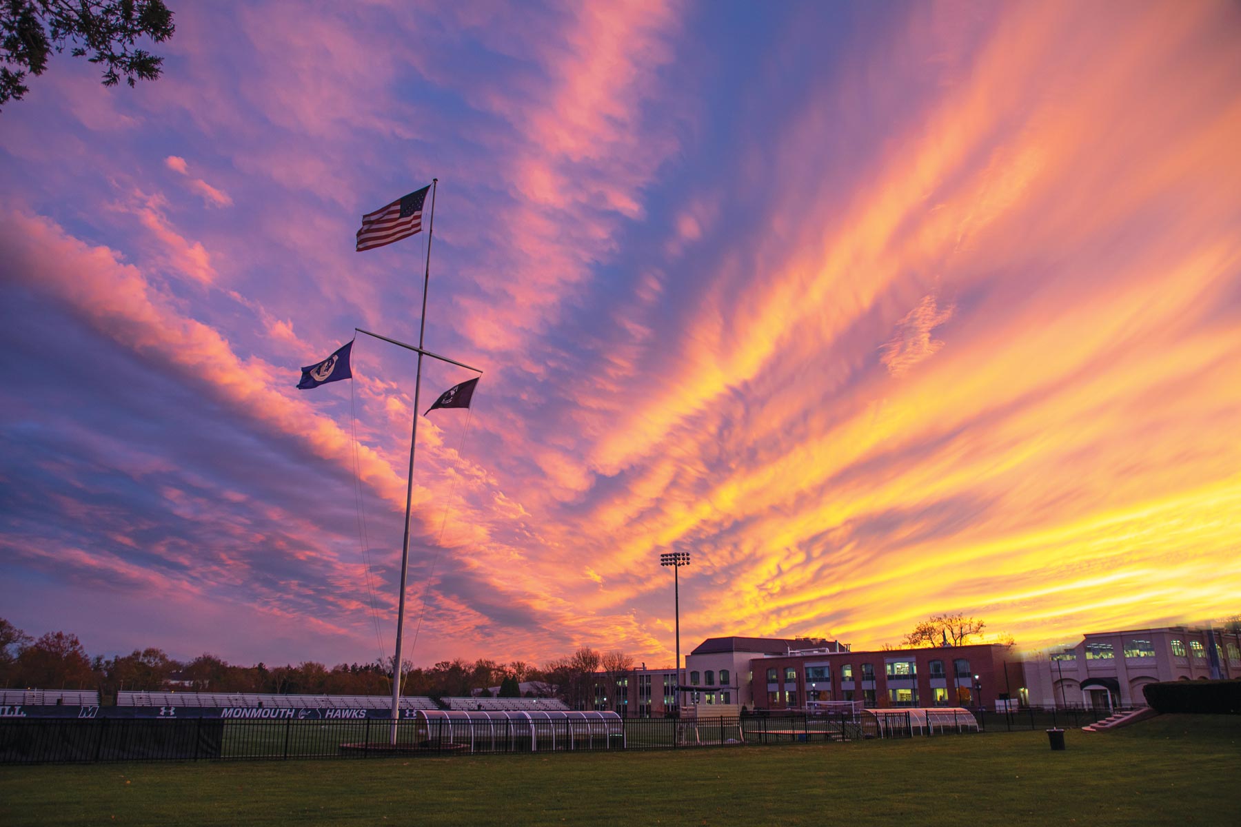 Campus field at sunset with flag pole
