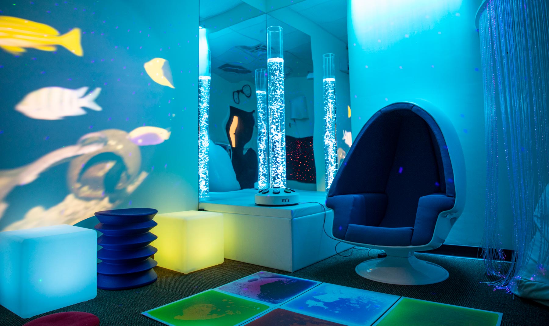 Multi-sensory room with egg chair and lots of different colored lights
