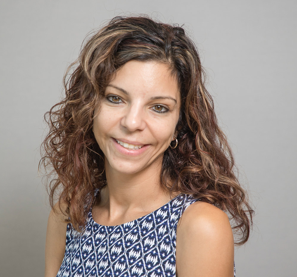 Tina Paone, Ph.D. in blue and white patterned suit