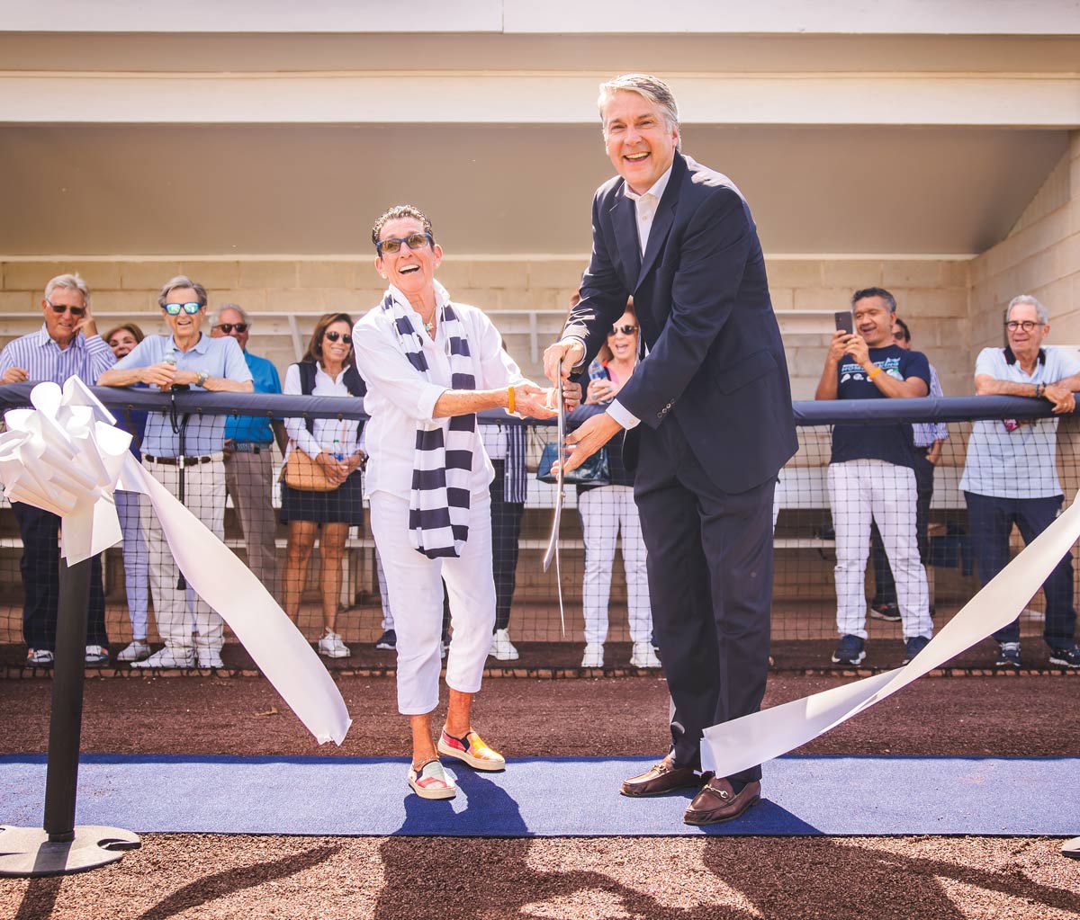 Henni K. Kessler and President Leahy holding scissors together to cut a white ribbon