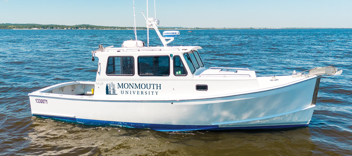 R/V Ocean Hawk with monmouth university logo printed on the side floating on water