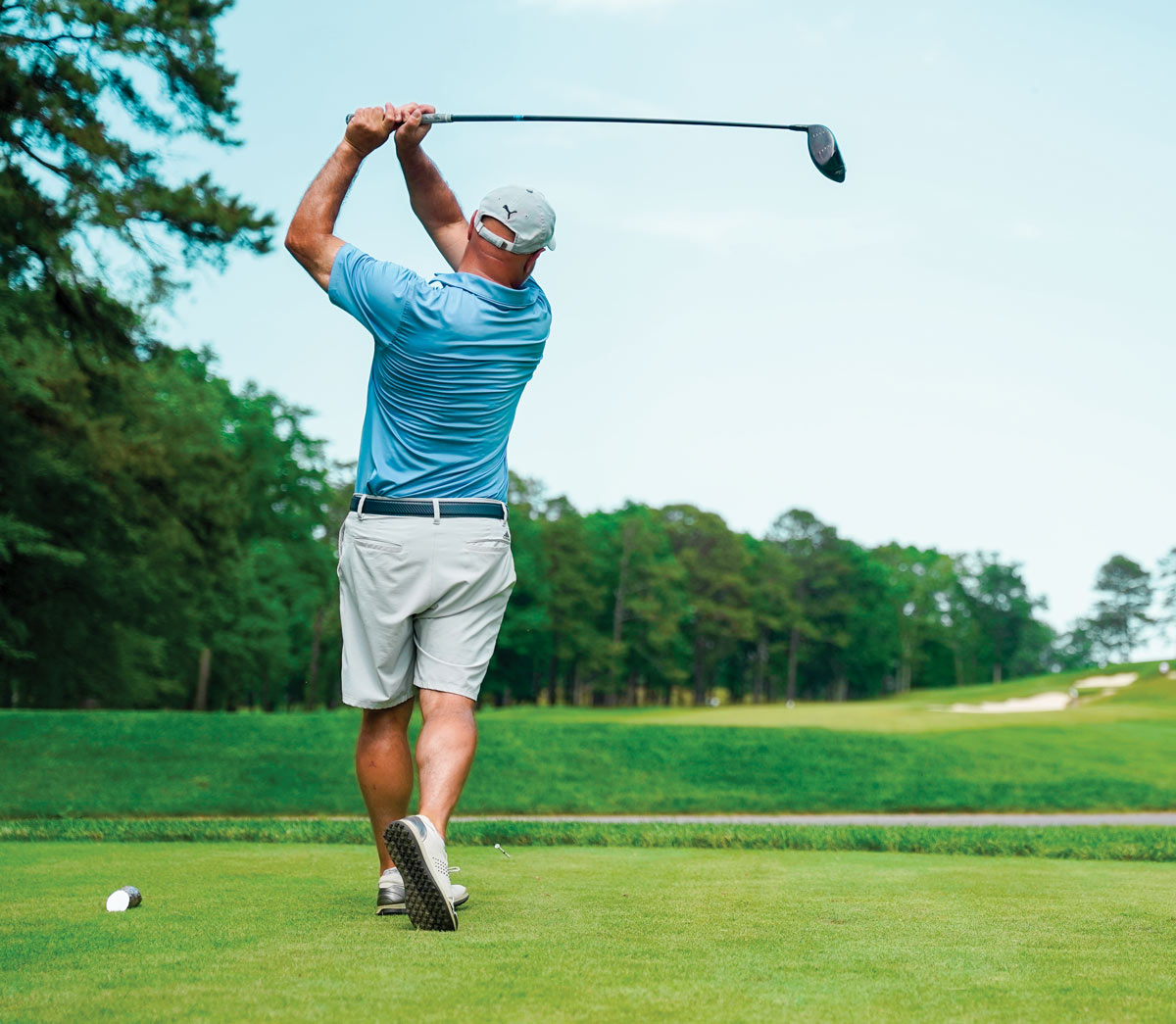 action shot of man swinging golf club