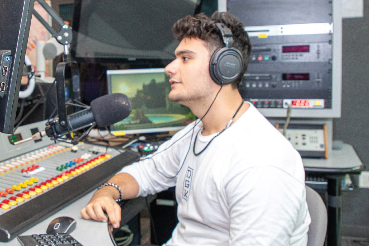 male student at microphone in recording studio